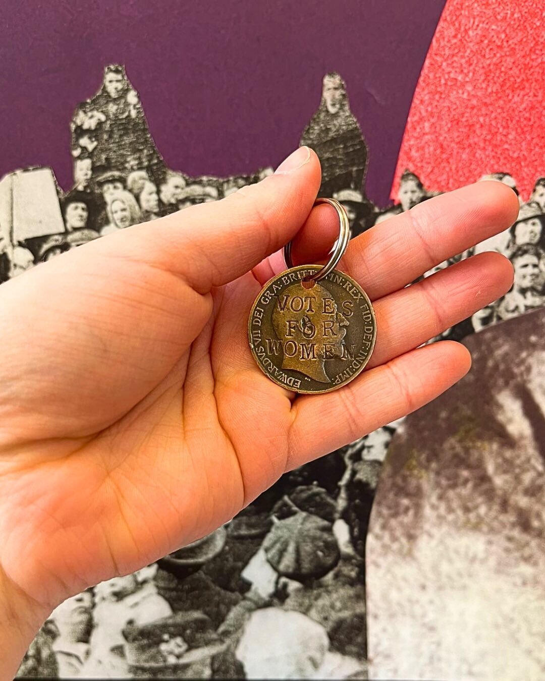 A hand holding a replica Suffragette Penny.